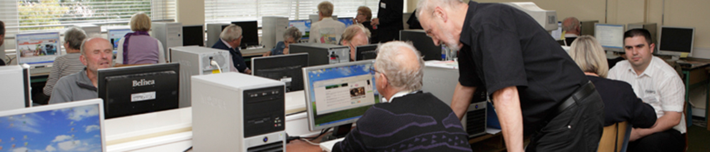 Mann hilft einem Senior am Computer