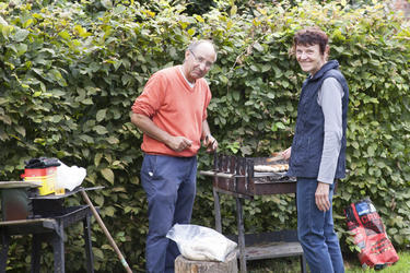 Ein Mann und eine Frau grillen Würstchen